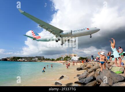 American Airlines Airbus A330 aeromobili su Maho Beach a Saint Maarten Antille olandesi. Spiaggia dell'aeroporto di St. Maarten famosa per gli aerei che passano sopra. Foto Stock