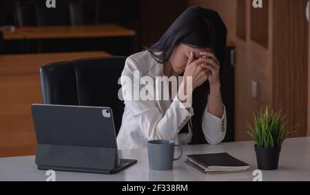 Donna d'affari ottiene stressata e mal di testa mentre ha un problema. Foto Stock