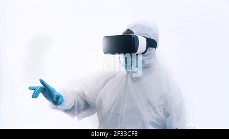 Medico nero afroamericano in uniforme protettiva e con occhiali VR. Chirurgia futuristica. Foto di alta qualità Foto Stock