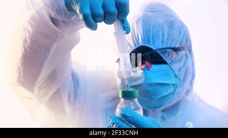 Vaccinazione e immunizzazione contro covid-19. Medico in uniforme completa preparazione del vaccino. Foto di alta qualità Foto Stock
