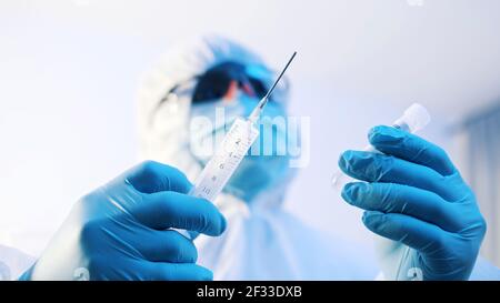 Vaccinazione e immunizzazione contro covid-19. Medico in uniforme completa preparazione del vaccino. Foto di alta qualità Foto Stock