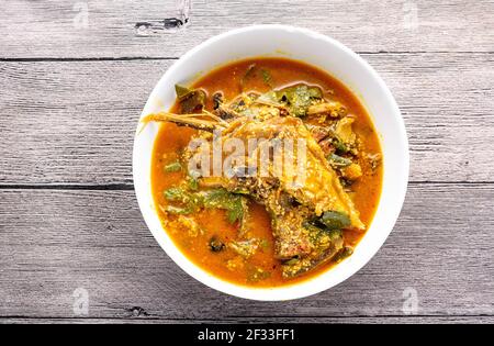 Immagine in alto zuppa OHA /ora con coda di bue e pesce in un piatto di ceramica bianca su sfondo di legno Foto Stock