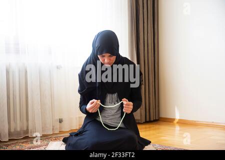 La giovane donna di Hijab sta pregando. Aiuto mubarak. ramadan musulmano Foto Stock