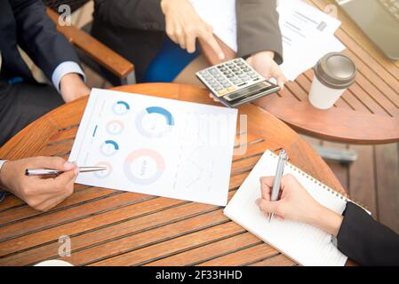 Uomini d'affari che calcolano e discutono i documenti finanziari sul tavolo in caffetteria Foto Stock