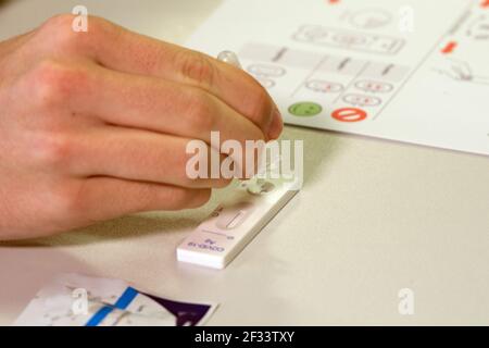 Bergisch Gladbach, Germania. 15 marzo 2021. Un allievo della Paffrath Municipal Integrated Comprehensive School esegue un test rapido Corona. Nonostante l'aumento delle infezioni, tutti gli alunni della Renania Settentrionale-Vestfalia tornano di nuovo in classe, almeno per un giorno. A Bergisch-Gladbach, la distribuzione di test di spit agli alunni inizia già un giorno prima delle altre scuole. Credit: Federico Gambarini/dpa/Alamy Live News Foto Stock