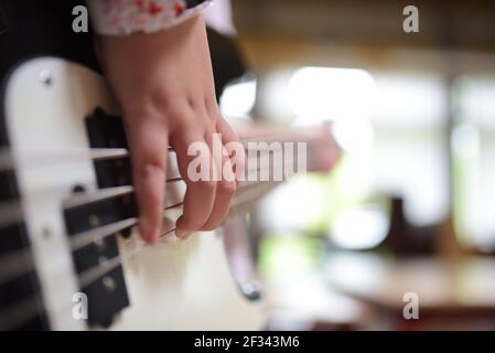 Una ragazza che suona una chitarra elettrica bianca Foto Stock