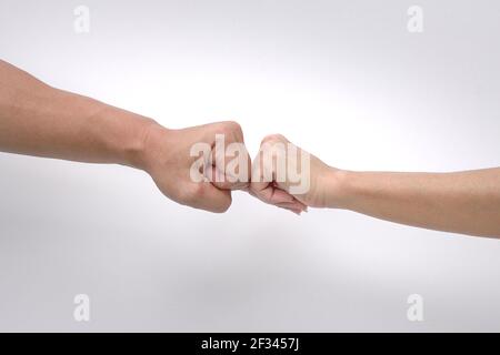 Primo piano di pugno di mani di un uomo e di una donna su sfondo bianco. Foto Stock