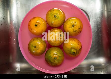 Ammollo di arance in acqua per pulire lo sporco su pelle Foto Stock