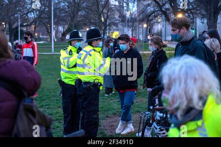 Brighton UK 13 marzo 2021 - la polizia inizia a spostare la gente mentre centinaia prendono parte ad una veglia a lume di candela per la vittima di omicidio Sarah Everard a Brighton questa sera . Riconquistare questi manifestanti di strada riuniti nei Giardini della Valle di Brighton per prendere parte alla veglia prima che la polizia iniziasse a muoverli dopo circa mezz'ora: Credit Simon Dack / Alamy Live News Foto Stock