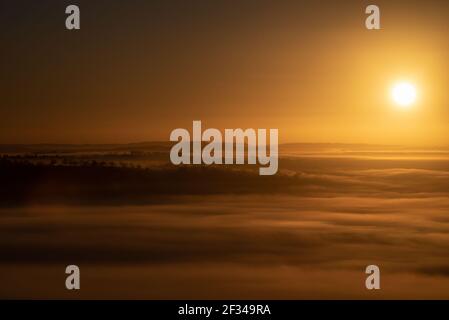 Glastonbury Tor, Glastonbury, Somerset, Regno Unito. 27 febbraio 2021. Le nebbie vorticose si trovano in basso attraverso i livelli del Somerset quando inizia la pausa. Foto Stock