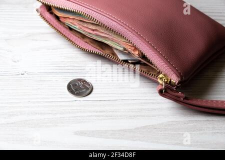 il portafoglio si trova sul tavolo accanto alla moneta. Concetto di finanza, reddito e spese, pagamento in contanti. Foto Stock