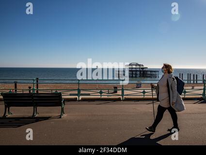 Un membro del pubblico che cammina intorno alla sfilata di Brighton mentre il tempo è soleggiato e chiaro questo fine settimana Foto Stock