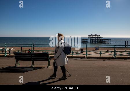 Un membro del pubblico che cammina intorno alla sfilata di Brighton mentre il tempo è soleggiato e chiaro questo fine settimana Foto Stock