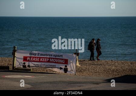 Un membro del pubblico che cammina intorno alla sfilata di Brighton mentre il tempo è soleggiato e chiaro questo fine settimana Foto Stock