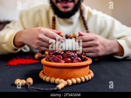 Uomo arabo musulmano che tiene il rosario con una certa data davanti di lui Foto Stock