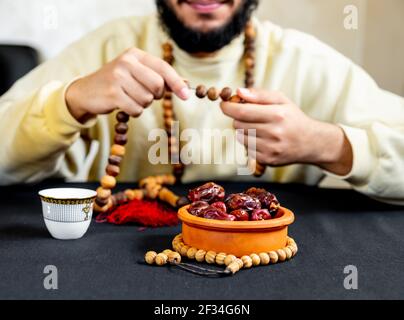 Uomo arabo musulmano che tiene il rosario con una certa data davanti di lui Foto Stock