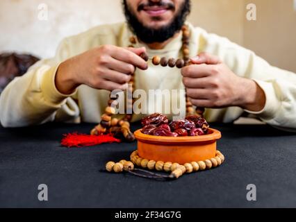 Uomo arabo musulmano che tiene il rosario con una certa data davanti di lui Foto Stock