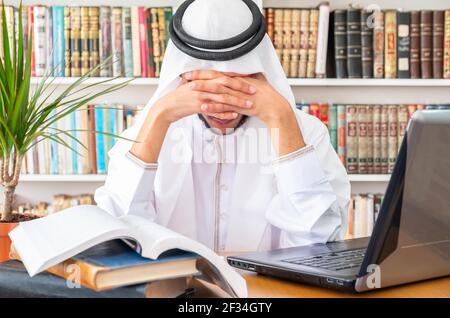 L'uomo arabo musulmano si sente sconvolto mentre studia online Foto Stock