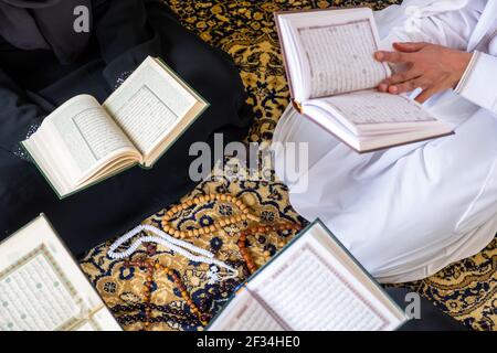 Vista dall'alto dei membri della famiglia musulmana che leggono insieme il quraan Foto Stock