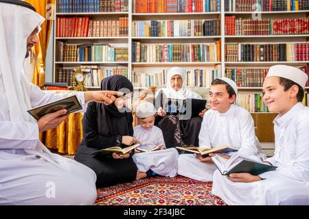 Felice famiglia arabica leggere e imparare quraan durante ramadan Foto Stock