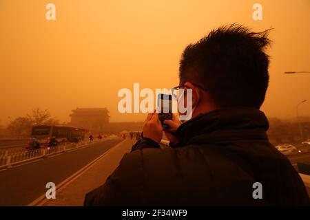 Pechino, Cina. 15 marzo 2021. Un uomo cinese scatta una foto di un tempio avvolto sotto una fitta tempesta di sabbia a Pechino lunedì 15 marzo 2021. In alcune aree intorno alla capitale, la forte tempesta di sabbia ha ridotto la visibilità a meno di 500 metri e 'è anche il più forte clima di polvere e sabbia che colpisce la Cina in quasi 10 anni', secondo l'Amministrazione Meteorologica Cinese. Foto di Stephen Shaver/UPI Credit: UPI/Alamy Live News Foto Stock