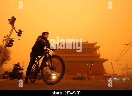 Pechino, Cina. 15 marzo 2021. Il ciclo cinese passa davanti a un tempio avvolto sotto una fitta tempesta di sabbia a Pechino lunedì 15 marzo 2021. In alcune aree intorno alla capitale, la forte tempesta di sabbia ha ridotto la visibilità a meno di 500 metri e 'è anche il più forte clima di polvere e sabbia che colpisce la Cina in quasi 10 anni', secondo l'Amministrazione Meteorologica Cinese. Foto di Stephen Shaver/UPI Credit: UPI/Alamy Live News Foto Stock