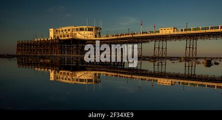 Worthing Pier durante la bassa marea all'alba nel Sussex occidentale Foto Stock