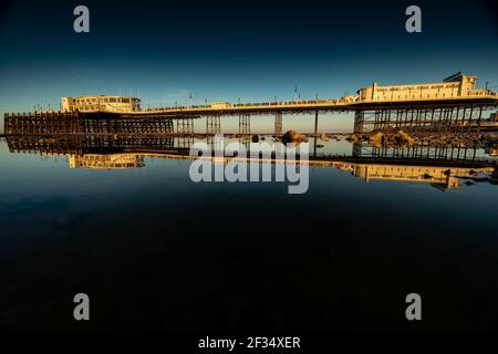 Worthing Pier durante la bassa marea all'alba nel Sussex occidentale Foto Stock