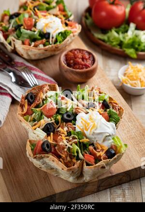 Insalata di Taco con pollo, lattuga, pomodoro, olive nere, formaggio e panna acida in guscio di tortilla Foto Stock