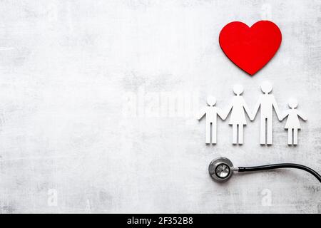 Piatto con cuore, stetoscopio e figura di famiglia. Concetto di assistenza medica Foto Stock