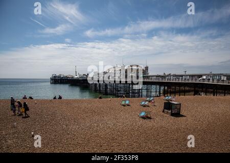 Le persone che si rilassano sulla spiaggia di Brighton, come restrizioni di blocco, sono state rilassate per consentire ai negozi non essenziali di riaprire in Inghilterra Foto Stock