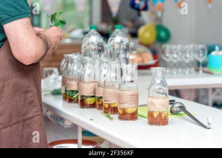 Barman mani maschio che tengono l'erba menta, preparando estate rinfrescante limonata bevanda Foto Stock