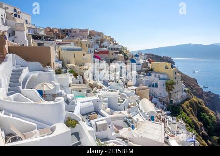 Grecia. Soleggiata giornata estiva a Santorini. Case bianche nella città di Oia sulla caldera e vista sul mare Foto Stock