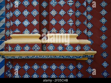 Terracotta e blu Talavera motivo simmetrico piastrellato con accenti bianchi e ocra sulla parete barocca di Santa María Tonantzintla a Cholula, Messico. Foto Stock