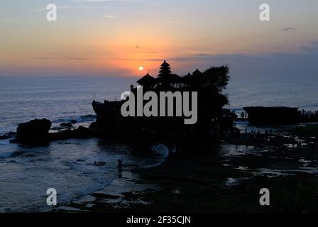 Uno dei più importanti templi balinesi pura Tanah Lot si trova su una scogliera direttamente sopra il mare; al tramonto, Bali, Indonesia Foto Stock