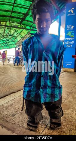 Barishal, Barishal, Bangladesh. 15 marzo 2021. Un ragazzo zoppo di circa 15 anni non ha genitori e a casa per questo ha dovuto rimanere alla stazione degli autobus nella città di Barishal in Bangladesh. Credit: Mustasinur Rahman Alvi/ZUMA Wire/Alamy Live News Foto Stock