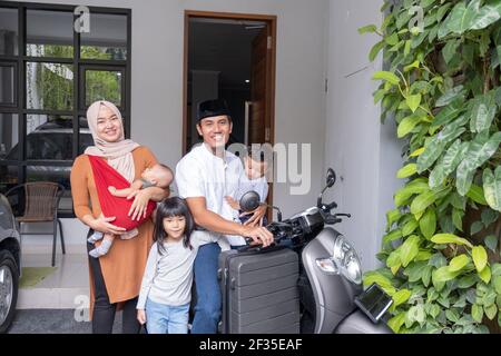 famiglia musulmana asiatica guidando scooter moto insieme viaggiare con il bambino Foto Stock