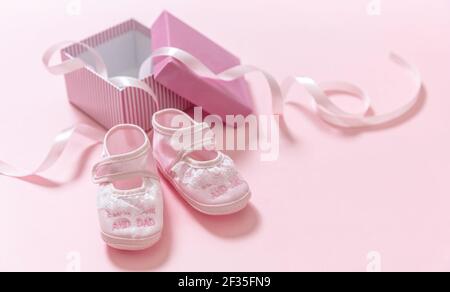 Doccia del bambino, concetto di battesimo della ragazza. Scarpe rosa per bambini su sfondo rosa. Si tratta di un modello di annuncio neonato per le ragazze. Footwea femminile morbida infantile Foto Stock