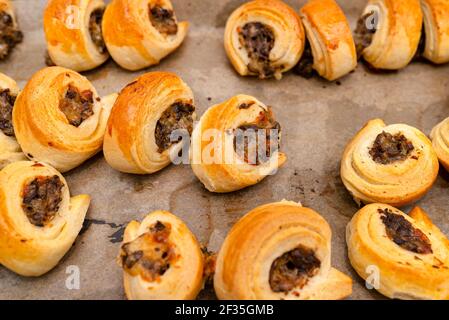 Polpettine dorate appena sfornate con funghi stesi su carta da forno. Foto Stock