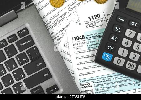 Scrivania da ufficio con moduli fiscali, computer portatile e calcolatrice, background aziendale Foto Stock