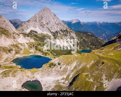 Vista elevata sul paesaggio alpino. Ripide cime rocciose e laghi limpidi nella natura protetta nei pressi di Ehrwald, Tirolo, Austria. Giornata di sole in montagna. Foto Stock