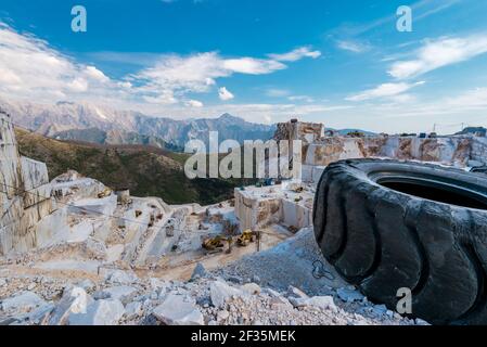 Vista panoramica della cava di marmo. Sito minerario di pietra decorativa bianca. Vecchio pneumatico usato danneggiato da macchine da costruzione. Foto Stock