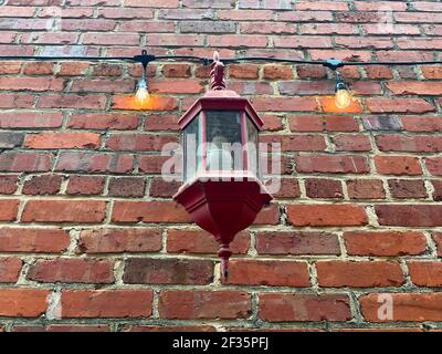 Wayesboro, GA USA - 02 11 21: Vecchio edificio in mattoni facciata vacanza luci vintage lampada guardando in su Foto Stock