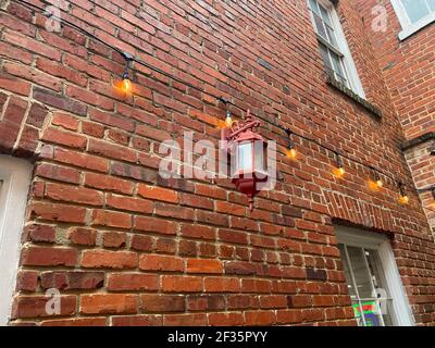 Wayesboro, GA Stati Uniti d'America - 02 11 21: Vecchio mattone edificio facciata vacanza luci vintage parete lampada Foto Stock