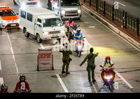 (210315) -- MANILA, 15 marzo 2021 (Xinhua) -- i poliziotti lavorano ad un checkpoint per gli automobilisti che passano durante l'attuazione di rigorose misure di quarantena a Manila, nelle Filippine, il 15 marzo 2021. Metro Manila, che ospita circa 13 milioni di persone, ha iniziato ad imporre di nuovo severe misure di quarantena il lunedì per contenere una recente ondata di infezioni da coronavirus. Il Dipartimento di Salute delle Filippine (DOH) ha riferito lunedì che 5,404 nuove infezioni da coronavirus (COVID-19), il più alto numero giornaliero in sette mesi, portando il numero totale di casi confermati nel paese a 626,893. (X Foto Stock