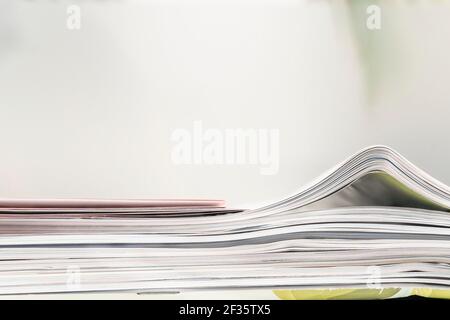 pila di riviste e file con messa a fuoco selettiva su soft sfondo con spazio di copia Foto Stock