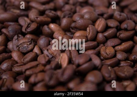 Primo piano sullo sfondo dei chicchi di caffè appena tostati. Vista dall'alto. Foto Stock