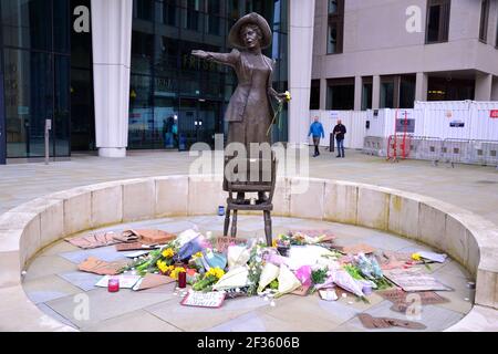 I cartelli che fanno lobby per la sicurezza delle donne e i fiori alla statua di Emmeline Pankhurst in St Peter's Square, Manchester, Inghilterra, Regno Unito, lasciarono dopo la veglia nella memoria di Sarah Everard il 13 marzo 2021. Il 12 marzo un ufficiale della polizia metropolitana di Londra è stato accusato del rapimento e dell'omicidio di Sarah Everard. Apparve alla corte dei Magistrati di Westminster il 13 marzo e fu rimesso in custodia per apparire all'Old Bailey il 16 marzo. Emmeline Pankhurst era il leader del movimento suffragette nel Regno Unito. La statua in bronzo fu scolpita da Hazel Reeves. Foto Stock