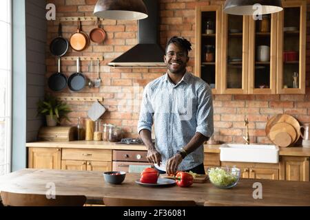 Sorridente giovane maschio nero Godetevi cucina moderna Foto Stock