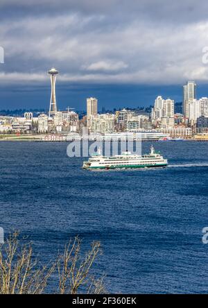 Un traghetto attraversa Elliott Bay di fronte ai grattacieli di Seattle, Washington. Foto Stock